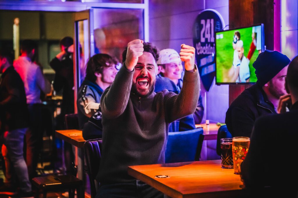 A fan celebrates watching Premier League football at a Belushi's Bar.