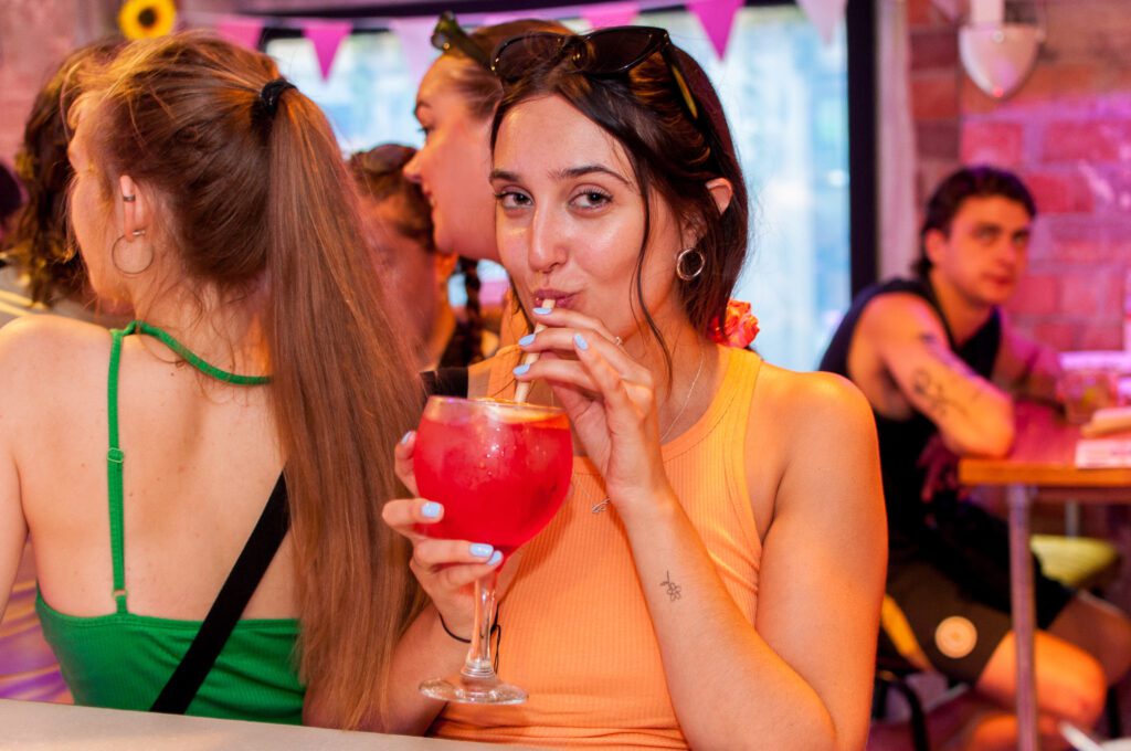 A girl drinks a cocktail in Belushi's Barcelona.