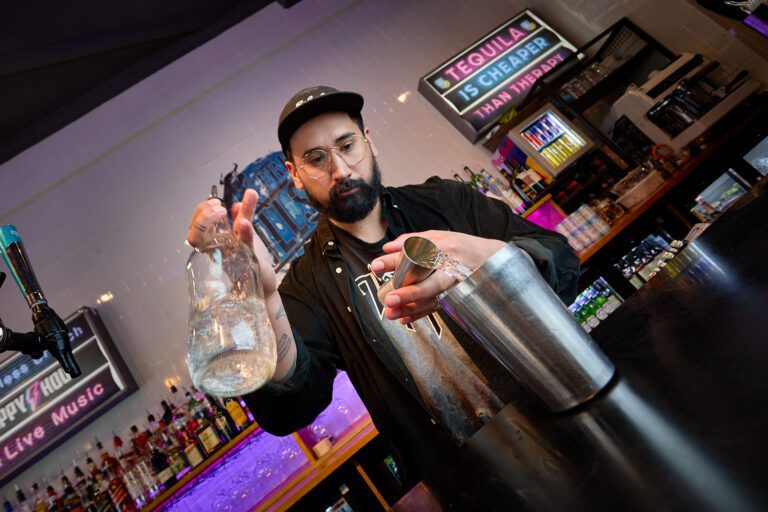 A bartender making cocktails at a Belushi's bar.