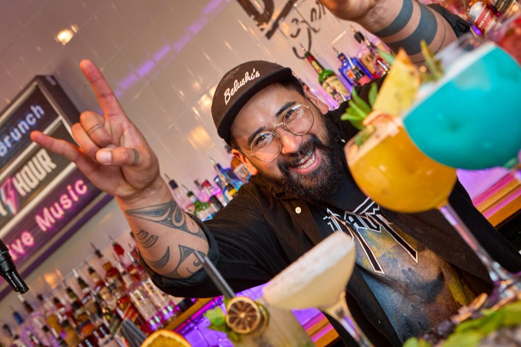 A bartender makes cocktails at a Belushi's bar.