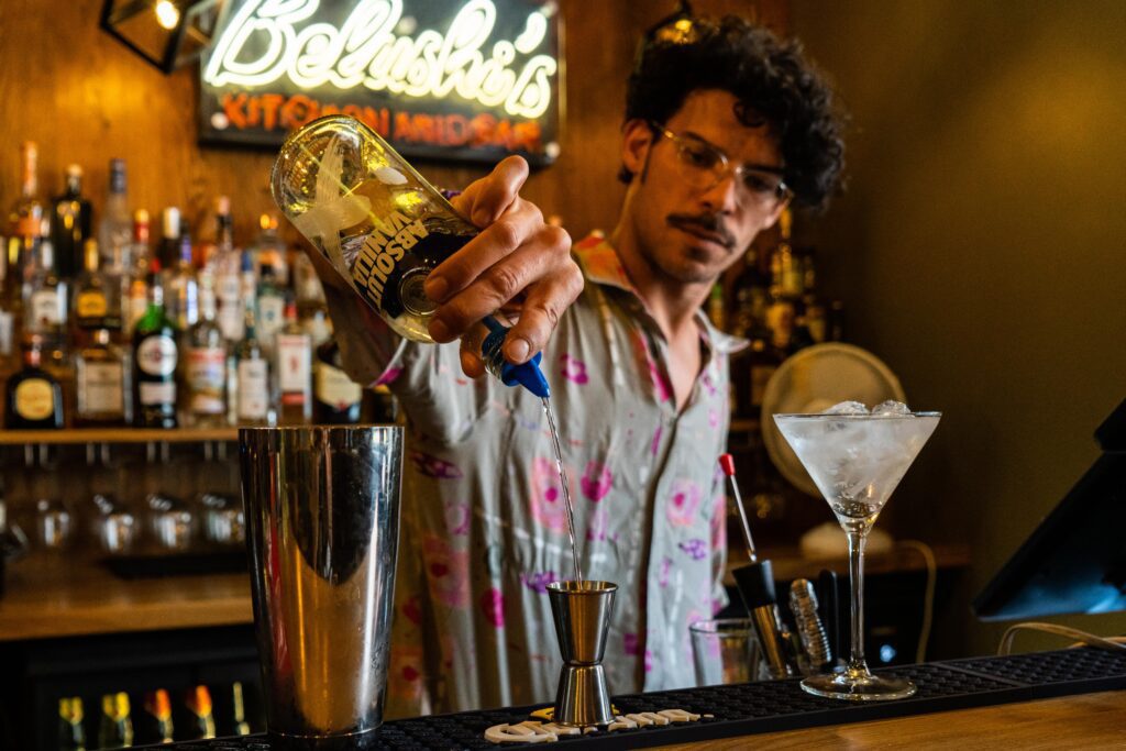 A bartender pours a cocktail in Belushi's bar in Vienna.