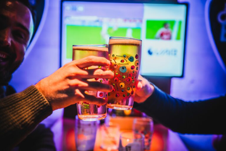 Friends 'cheers' in front of a game of Premier League football at a Belushi's Bar.