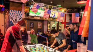 A group of friends play table football in Belushi's Camden.