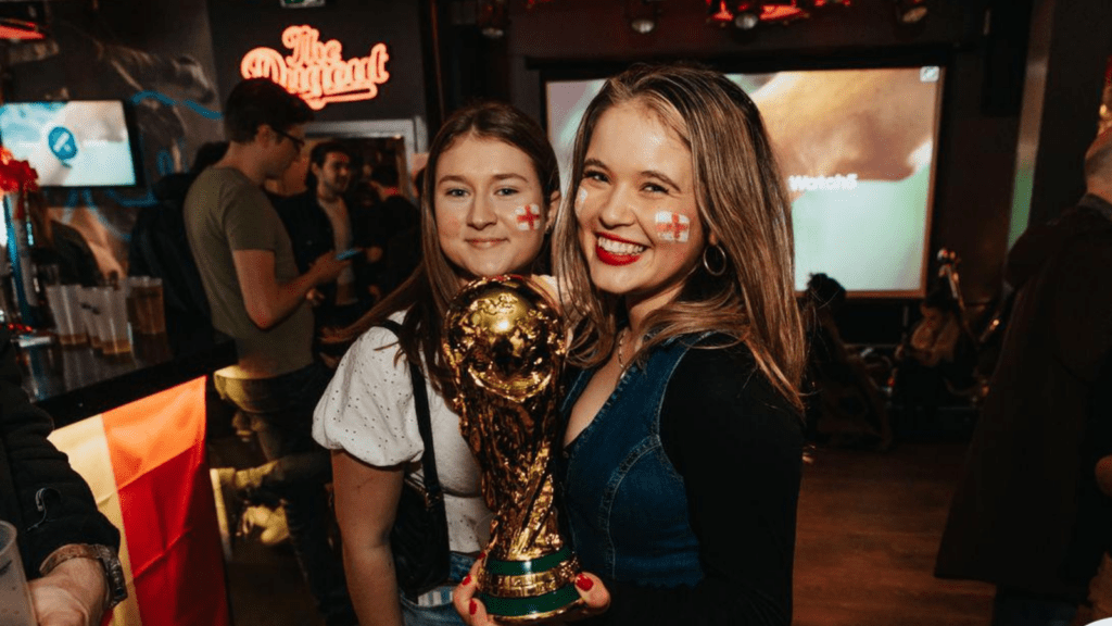 Two female football fans watch a game in a Belushi's Bar.