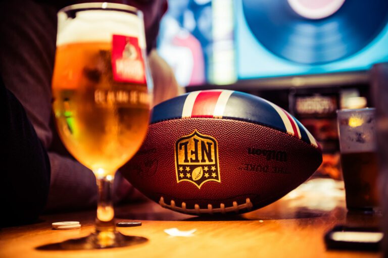 A pint and an NFL football on a table at a Belushi's Bar.