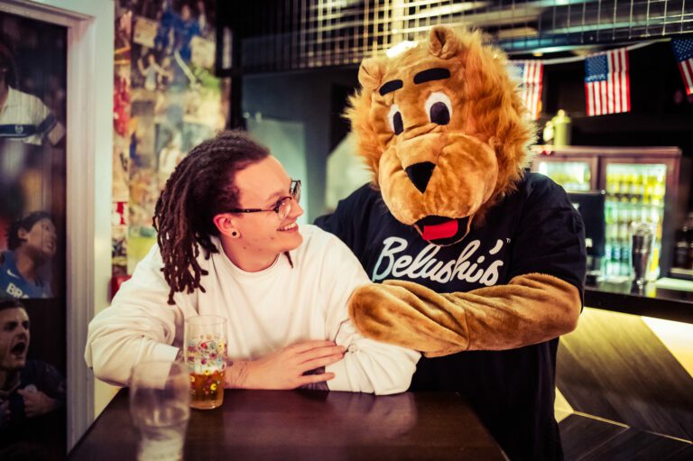 A football fan with an NFL mascot at a Belushi's Bar.