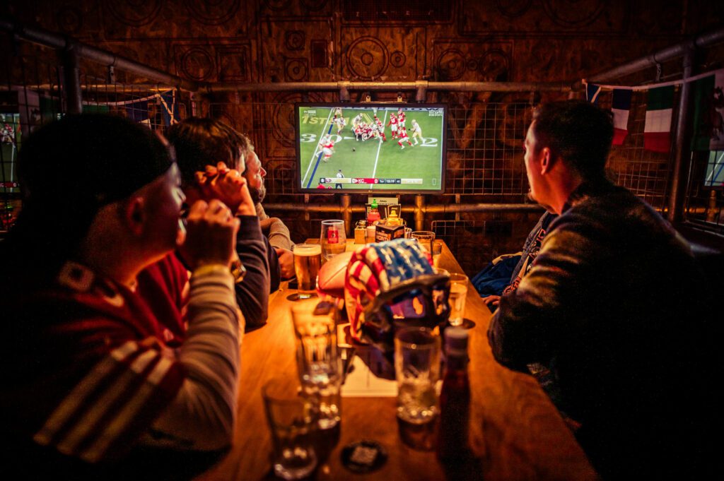 A group of football fans watch the NFL in a booth at a Belushi's Bar.