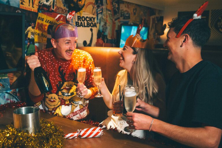 Friends laugh at a Christmas party at a Belushi's Bar.