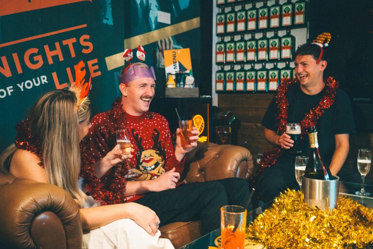 Friends laugh at a Christmas party at a Belushi's Bar.