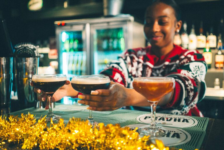 A bartender in Christmas attire serves cocktails.