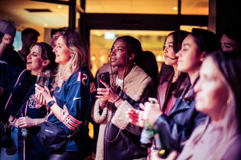 Female fans watch NFL at a Belushi's Bar.