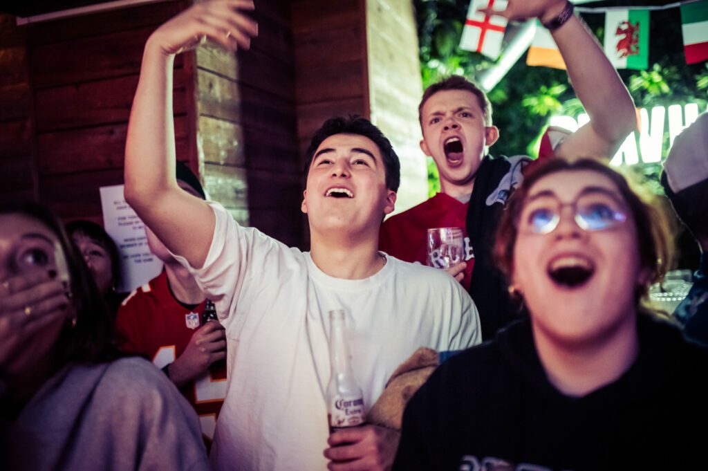 A group of football fans celebrate a touchdown in the NFL at a Belushi's Bar.