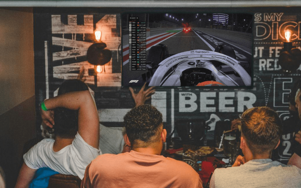 F1 fans watch a race in a private space in a Belushi's Bar.