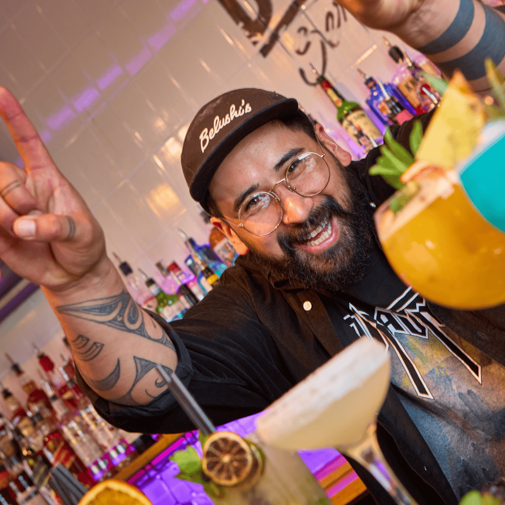 A bartender serves up a range of colourful cocktails in a Belushi's Bar.