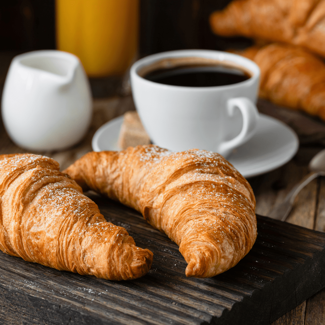 A cup of coffee and two croissants