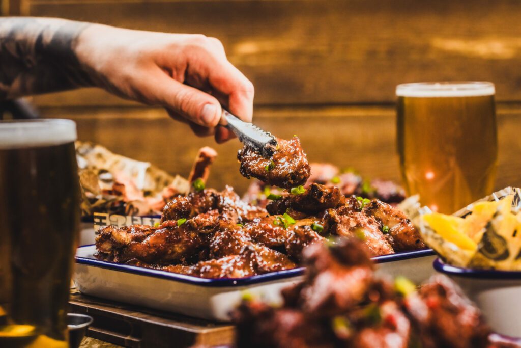 A chef serves up a platter of wings in a Belushi's Bar.