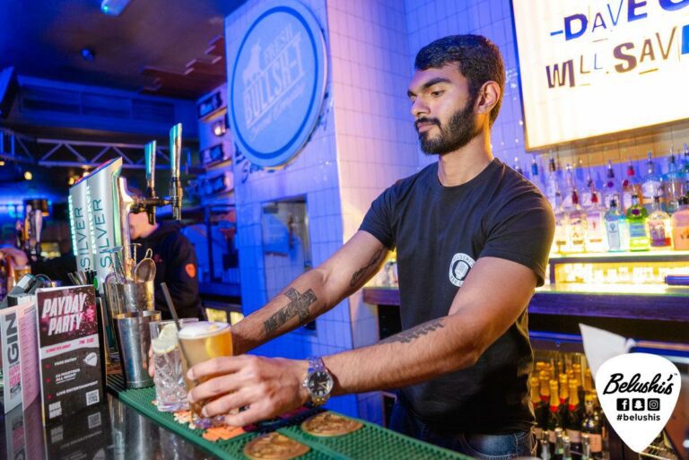 A bartender serves cocktails in a Belushi's Bar.