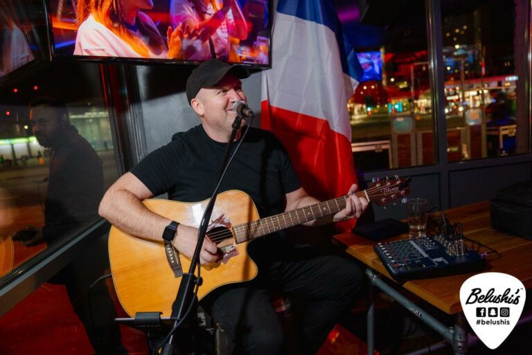 A man sings with a guitar in Shepherd's Bush Belushi's.