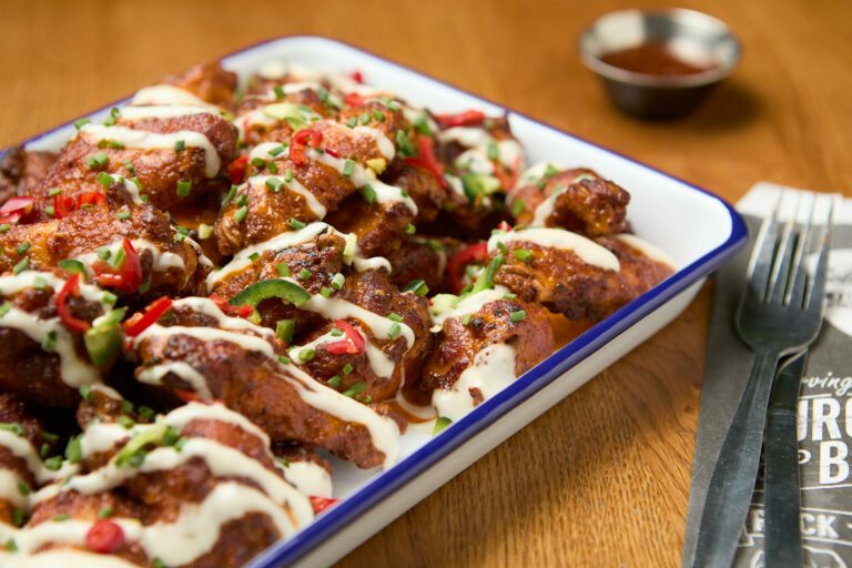 A side-on view of a platter of chicken wings at a Belushi's Bar.