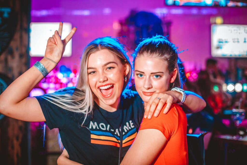 Two girls celebrating in a Belushi's Bar.