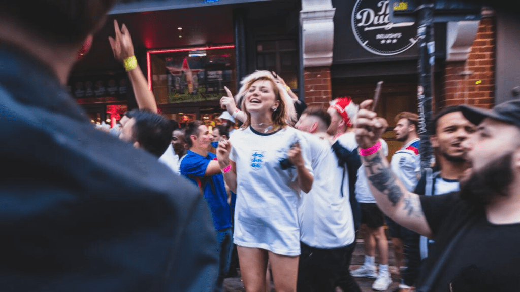 Football fans celebrate outside a Belushi's Bar.