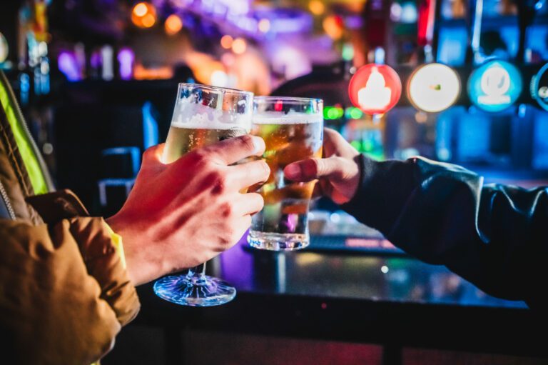 Two friends cheers craft beers in a Belushi's Bar.