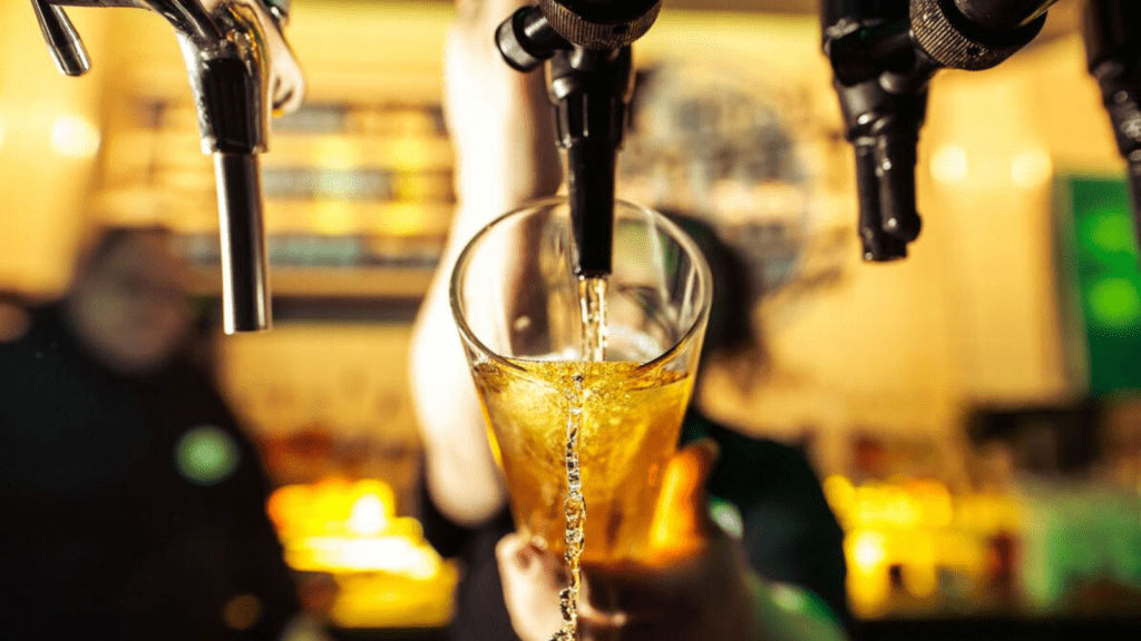 A bartender pours a pint of craft beer at a Belushi's bar.