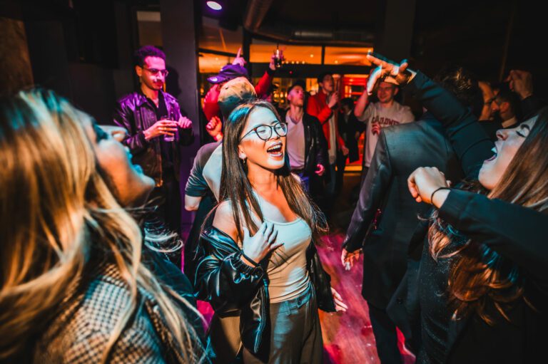 A group of female friends dance and laugh in a Belushi's Bar.