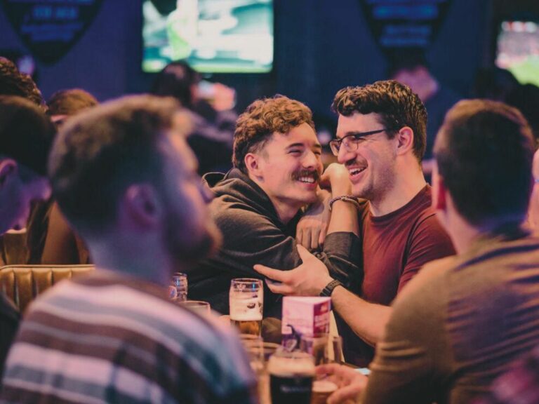 Two men laughing at a bar