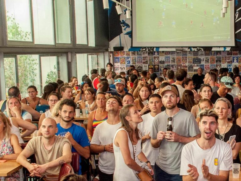 A crowded bar watching live football on screens