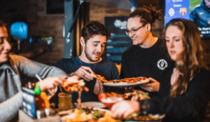 Friends enjoy pizza at a Belushi's bar