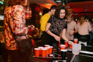 A group of customers playing beer pong at a Belushi's bar