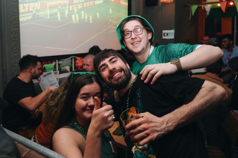 An image of 3 people smiling for the camera, dressed in St Patricks Day colours