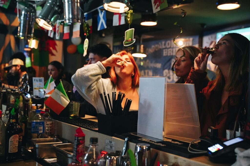 An image of three Belushi's customers drinking shots at the bar