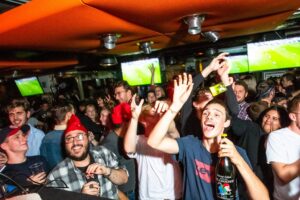 An image of a group of customers celebrating a six nations game on large HD screens at a Belushi's bar