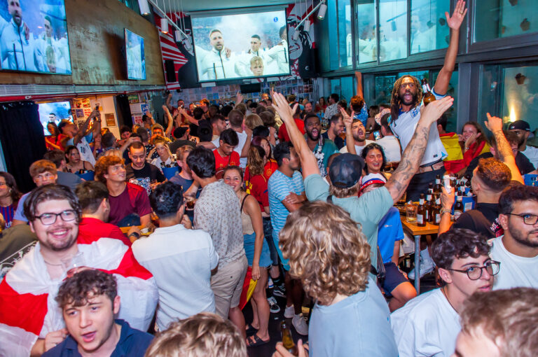 Football fans enjoying football game on large HD screens at a Belushi's bar