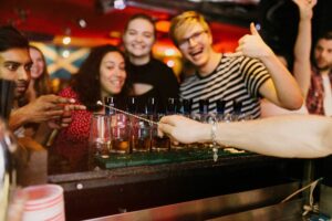 An image of a group waiting for their shots to be served at a Belushi's bar