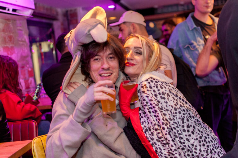 An image of a woman and a man, dressed up for Halloween, at a Belushi's bar