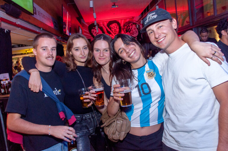 A picture of a group of friends drinking beer at a Belushi's bar