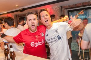 Two men at a Belushi's bar, wearing football t shirts