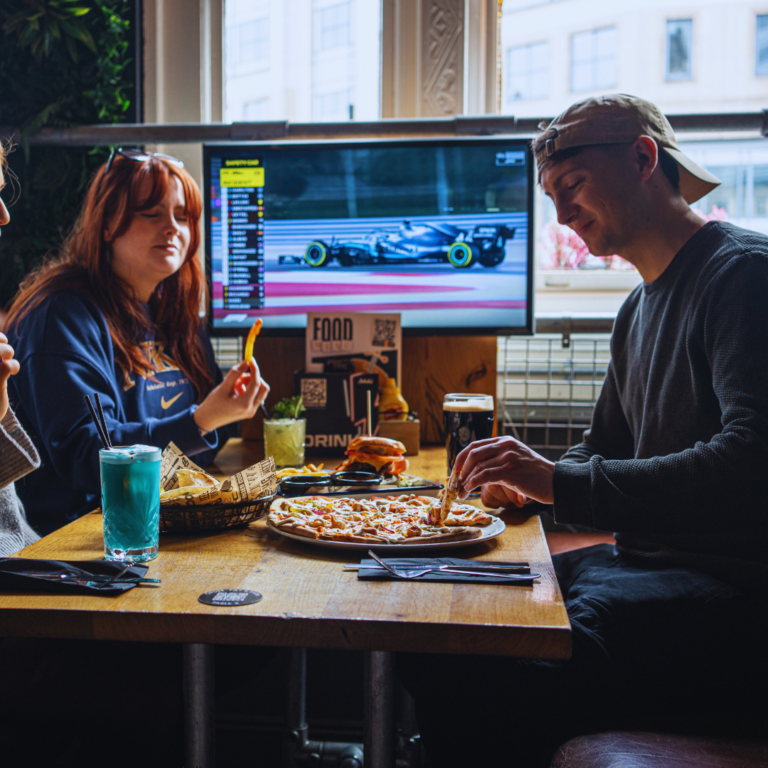 Customers eating and drinking while watching the 2024 F1 at a Belushi's bar