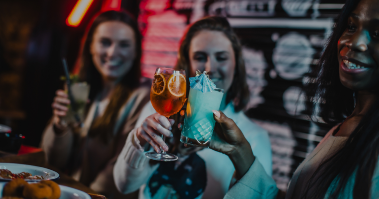 A group of people cheersing with cocktails at Belushi's