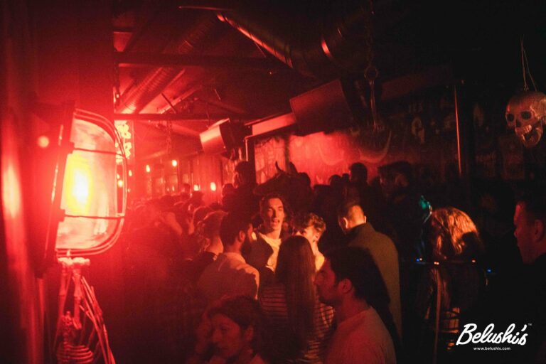 An image of a Belushi's bar with Halloween decorations and customers dancing