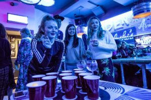 An image showing a group of friends playing beer pong.