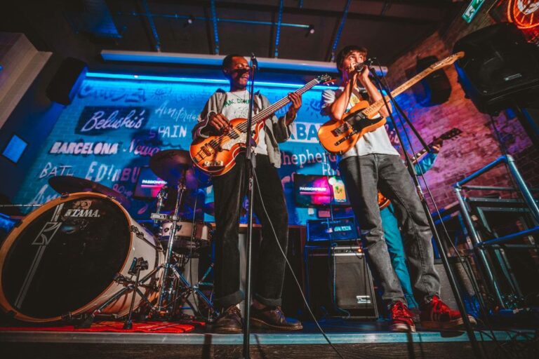 Two live performers play guitar and sing at a Belushi's bar